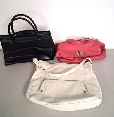 three purses are lined up on a table next to each other