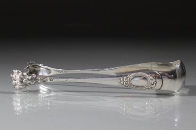 une cuillère en argent ornée d'une fleur, posée sur une table
