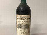 une bouteille de vin rouge posée sur une table blanche