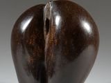 sculpture représentant une aubergine fendue en son milieu, posée sur une surface blanche