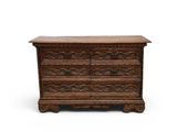 une vieille commode en bois ornée de sculptures sur le dessus