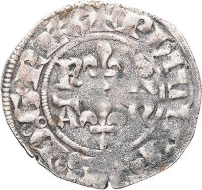 une vieille pièce d'argent sur laquelle figure un motif circulaire