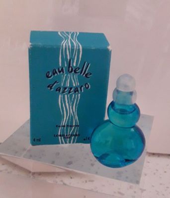 une image représentant un flacon de parfum bleu posé sur une table