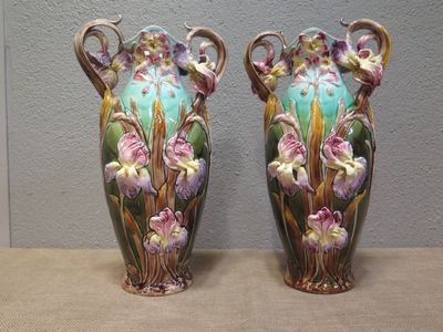 two vases with flowers painted on them sitting on a table