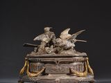 une sculpture antique en bronze représentant des oiseaux, posée sur un socle