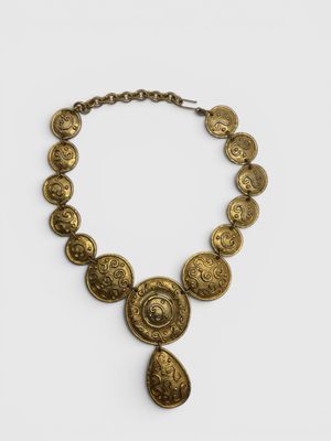 a gold necklace with coins on a chain on a white background