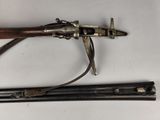 rifle with a wooden handle and a metal handle on a white surface