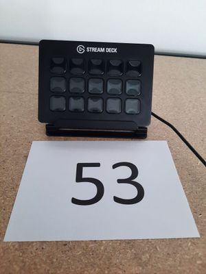 un clavier noir posé sur une table, à côté d'un panneau blanc