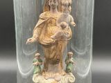 statue d'une femme tenant un enfant dans ses bras, sous un dôme de verre