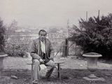 photographie en noir et blanc d'un homme assis sur un banc dans un parc