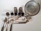 a lot of silverware sitting on a white table
