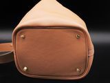 a brown leather bag sitting on top of a black surface