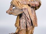 statue of a man with a beard and a hat holding a book and a dog