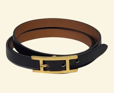Gros plan sur une ceinture noire avec une boucle dorée