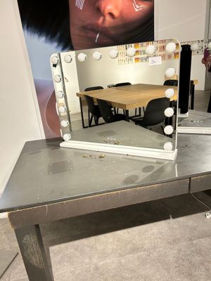a table that has a mirror on it with lights on it
