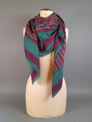 une écharpe rayée violette et verte sur une tête de mannequin