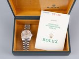 a rolex watch in a box with a booklet
