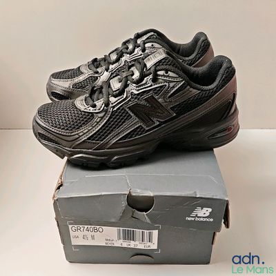a box with a pair of new balance shoes on top of it