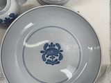 a white plate with a blue flower on it next to other plates