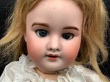 a close up of a doll with blonde hair and blue eyes