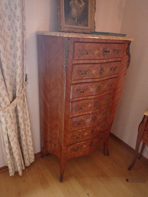 une commode sur laquelle est posée une photo, dans une pièce