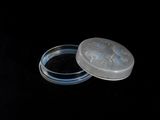 a small plastic container with a lid on a black surface
