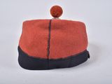 an orange and black purse with a pom pom on top of it
