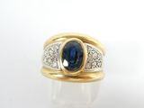gros plan d'une bague en or avec un saphir et des diamants