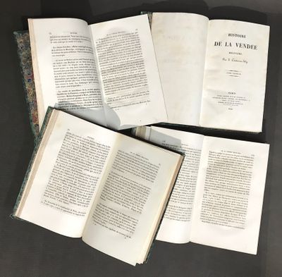 trois livres ouverts posés sur une table l'un à côté de l'autre