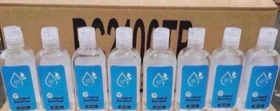 six bouteilles d'eau sont alignées sur une étagère devant un carton