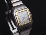 une montre-bracelet argentée et dorée sur fond noir