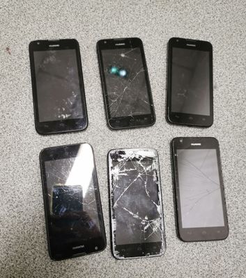 four cell phones are sitting next to each other on a table