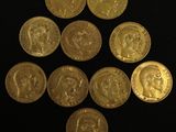 a close up of a bunch of gold coins on a black surface