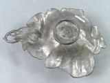 a silver plate with a candle on it on a table