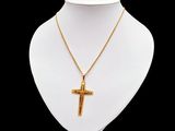 a gold necklace with a cross on a mannequin neck