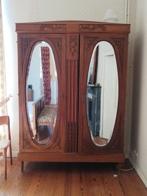 une armoire en bois surmontée de deux miroirs