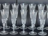 six verres à vin transparents sont alignés sur une surface noire