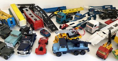 un grand nombre de voitures et de camions jouets qui se trouvent sur la table