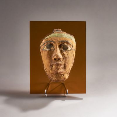a picture of a sculpture of a man ' s face on a stand
