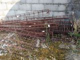 a pile of rusted iron bars on the ground next to a wall
