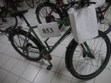 a green bicycle with a white bag on the back of it