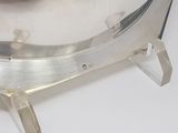 a silver plate that is on a stand on a white surface