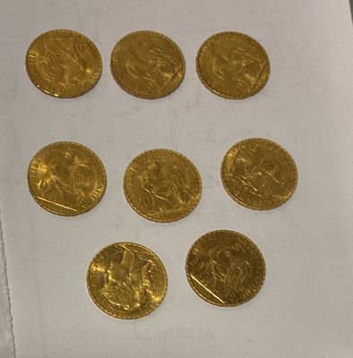 several gold coins sitting on top of a piece of paper on a table
