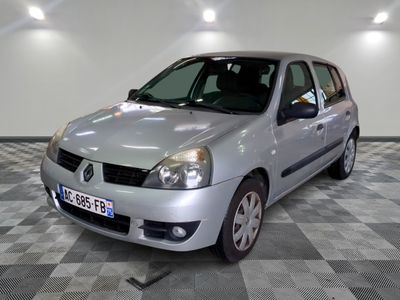 une petite voiture argentée garée dans une pièce au sol en damier