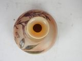 a small vase with a design on it sitting on a table