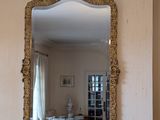 a mirror on the wall above a fireplace in a living room