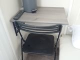 a small table with a chair and a trash can on it