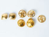six pairs of goldtone buttons and a pair of goldtone buttons