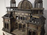 a wooden model of a building on a marble table