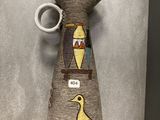 un vase orné d'un oiseau, exposé dans une vitrine